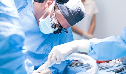 An oral surgeon placing a dental implant post
