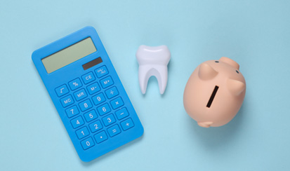 a piggy bank, calculator, and model tooth 