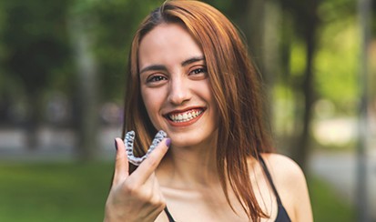 a close-up of a patient holding her Invisalign aligner