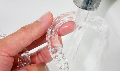a patient rinsing off their clear aligner