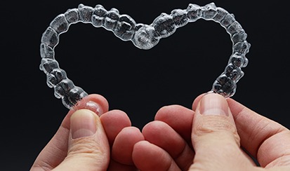 a closeup of two Invisalign aligners in the shape of a heart