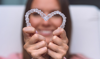 a patient holding two Invisalign aligners