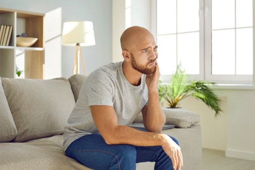 Man holding cheek due to toothache