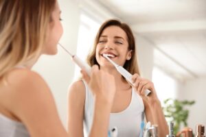 a person smiling while examining their toothbrush