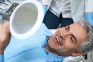 a patient examining their new dental crown