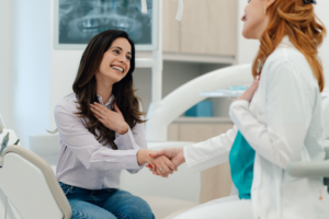 a dentist and patient smiling and chatting