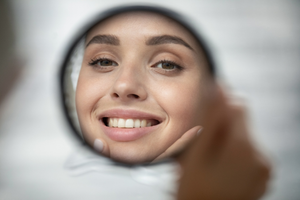 a person examining their smile in a mirror